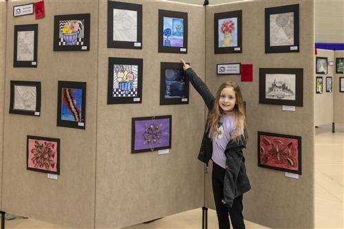 Elementary student with their artwork
